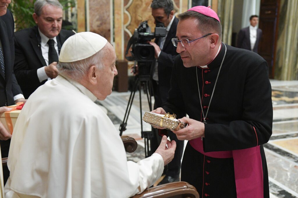 Pope Francis receives a gift from Bishop Andrea Migliavacca of Arezzo-Cortona-Sansepolcro, Italy, who accompanied Franciscan friars from La Verna and from Tuscany to the Vatican April 5, 2024, as part of the Franciscans' celebrations of the 800th anniversary of St. Francis of Assisi receiving the stigmata.