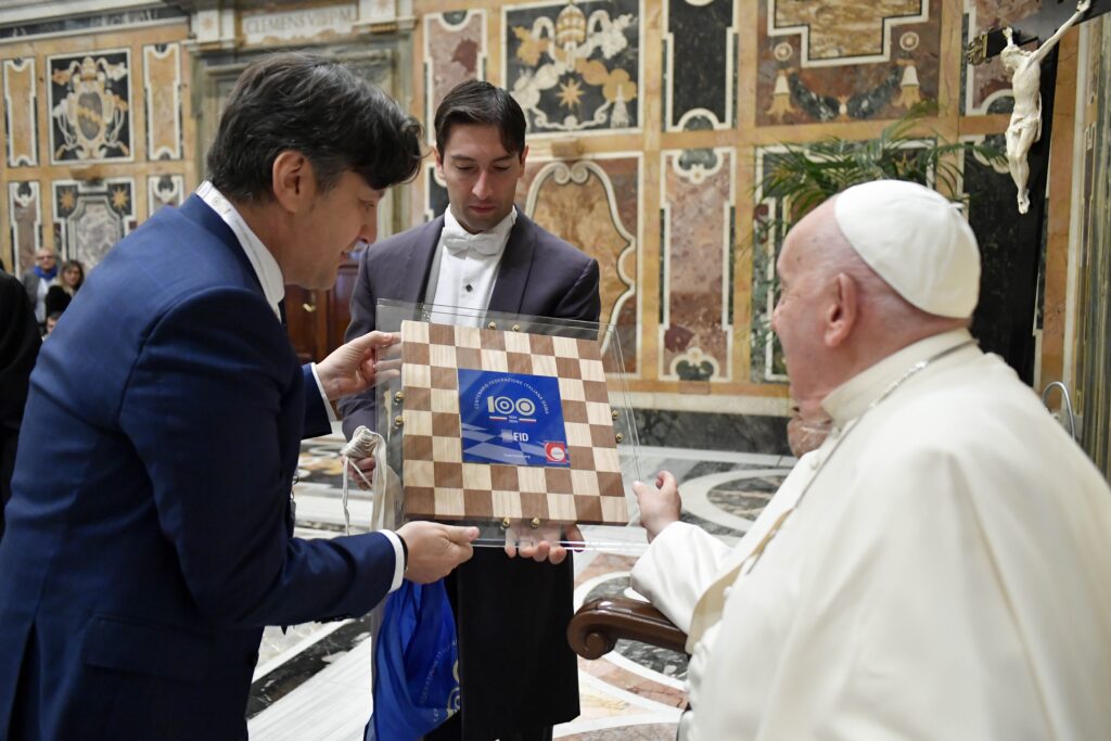 Pope Francis receives a wooden checkerboard from members of the Italian Checkers Federation during a meeting at the Vatican April 26, 2024.