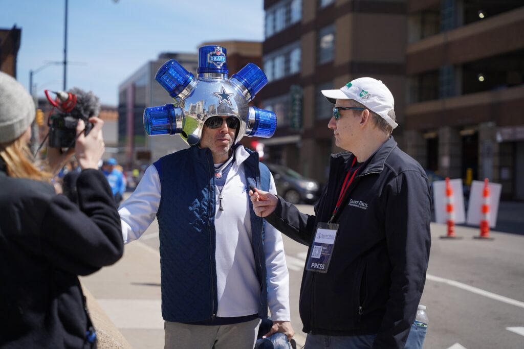 Bob Wilson, director of St. Paul Street Evangelization, interviews a Dallas Cowboys fan outside the NFL Fan Zone near Campus Martius Park in downtown Detroit before the start of the NFL Draft on April 25, 2024.