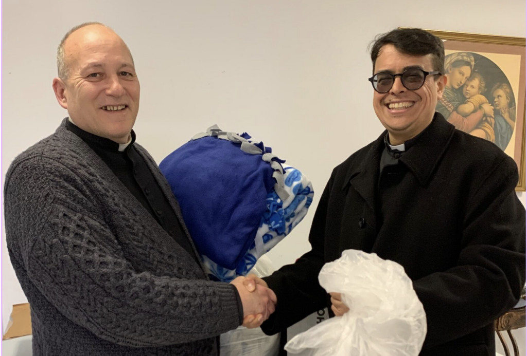 Father Arthur Rojas (right), the pastor of Presentation-Sacred Heart Parish at Port Ewen and Esopus, delivered to Father Kenneth Riello, the pastor of St. Mary and St. Andrew's Churches, boxes and bags of homemade blankets and shawls from his parishioners for distribution via the Food Pantry at Father Riello's parish.