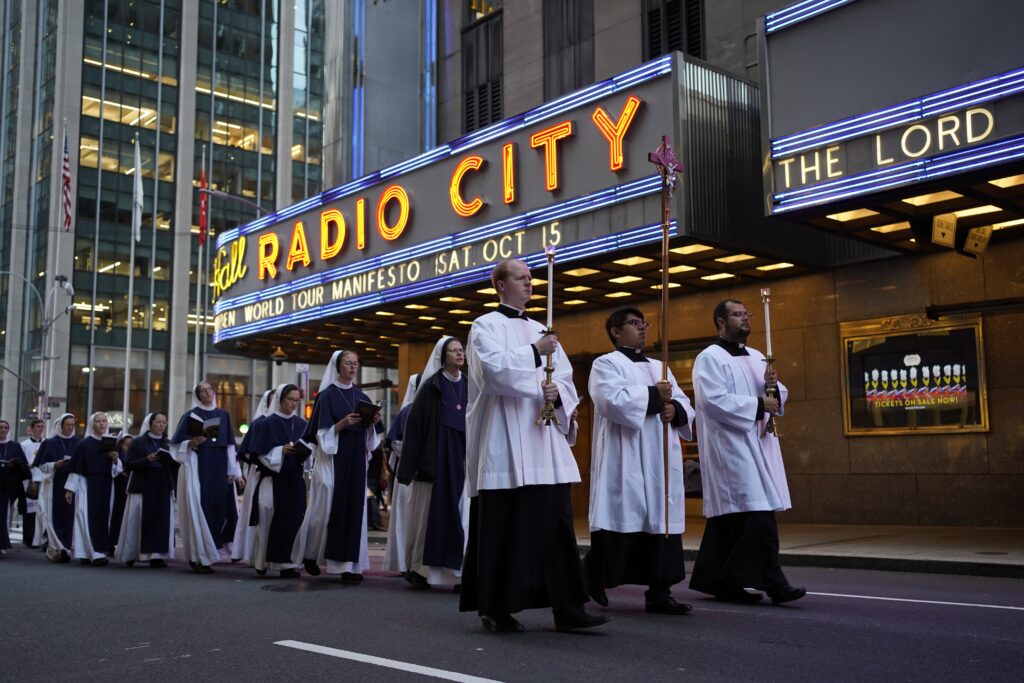Seminarians lead a eucharistic procession as it passes Radio City Music Hall in New York City Oct. 11, 2022.