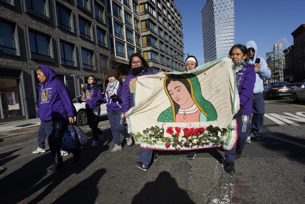 Women carry a banner featuring an image of Our Lady of Guadalupe after attending a Mass marking the Marian feast at the Co-Cathedral of St. Joseph in the Prospect Heights section of Brooklyn, December 12, 2023.