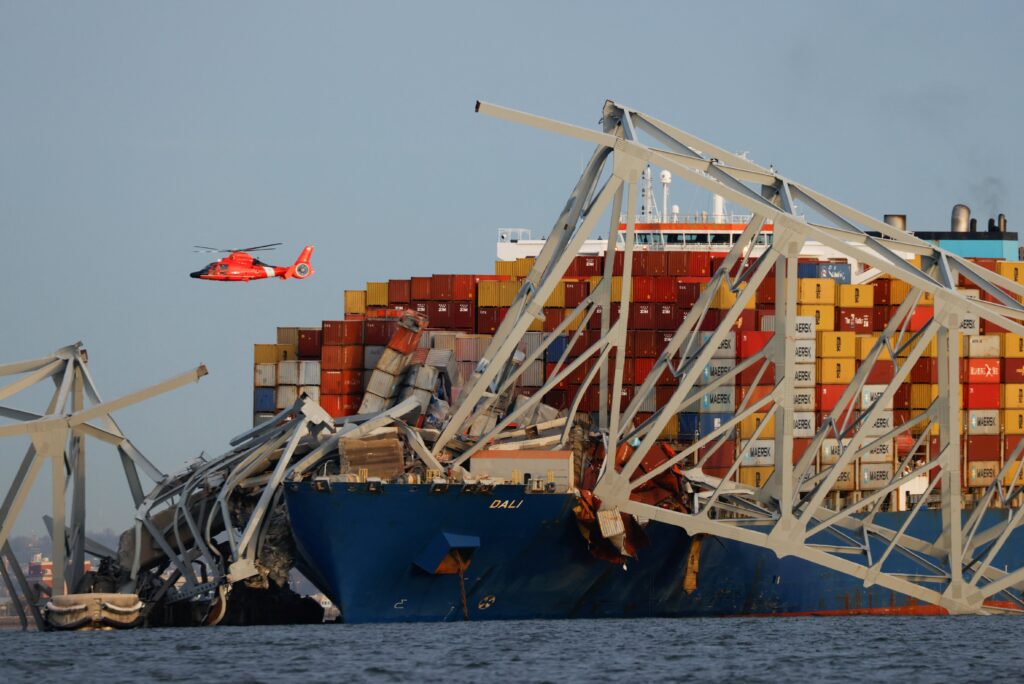 A U.S. Coast Guard helicopter hovers over the Dali cargo vessel March 26, 2024, after it crashed into the Francis Scott Key Bridge causing it to collapse in Baltimore.