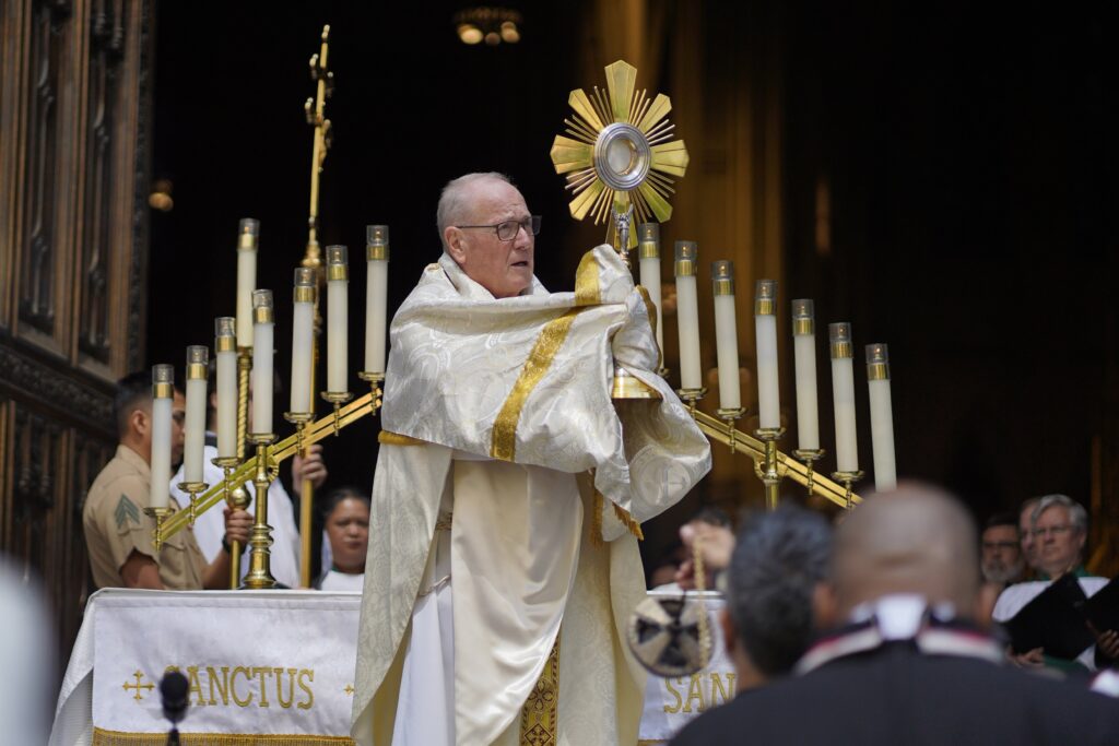 Cardinal Timothy M. Dolan elevates the monstrance in front of the main doors of St. Patrick's Cathedral in Manhattan during Eucharistic adoration following Mass on May 26, 2024, the solemnity of the Most Holy Trinity.