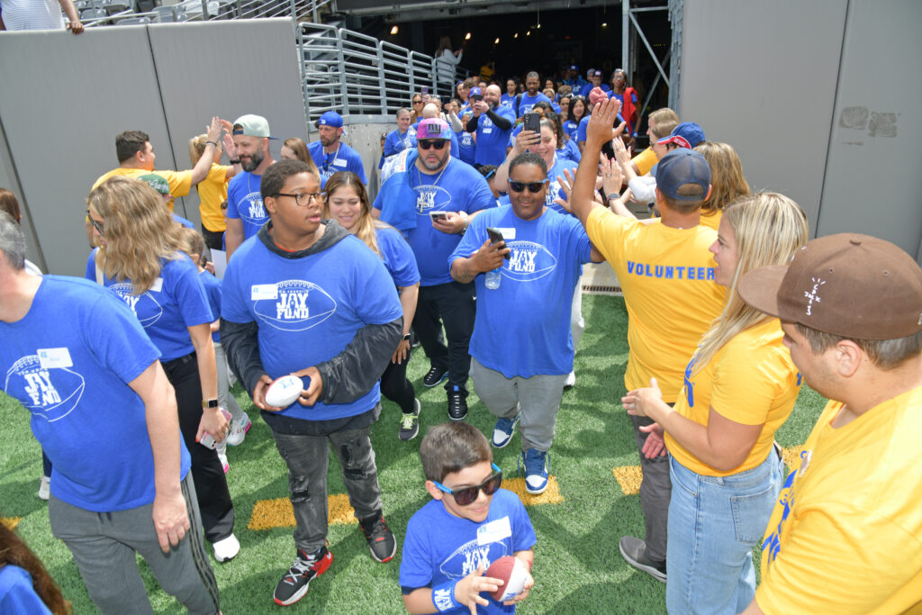 Families, caregivers, and volunteers take the field at MetLife Stadium, at an event organized by the Tom Coughlin Jay Fund. The Fund has received grants from the Mother Cabrini Foundation for its work in support of families with childhood and teenage cancer.