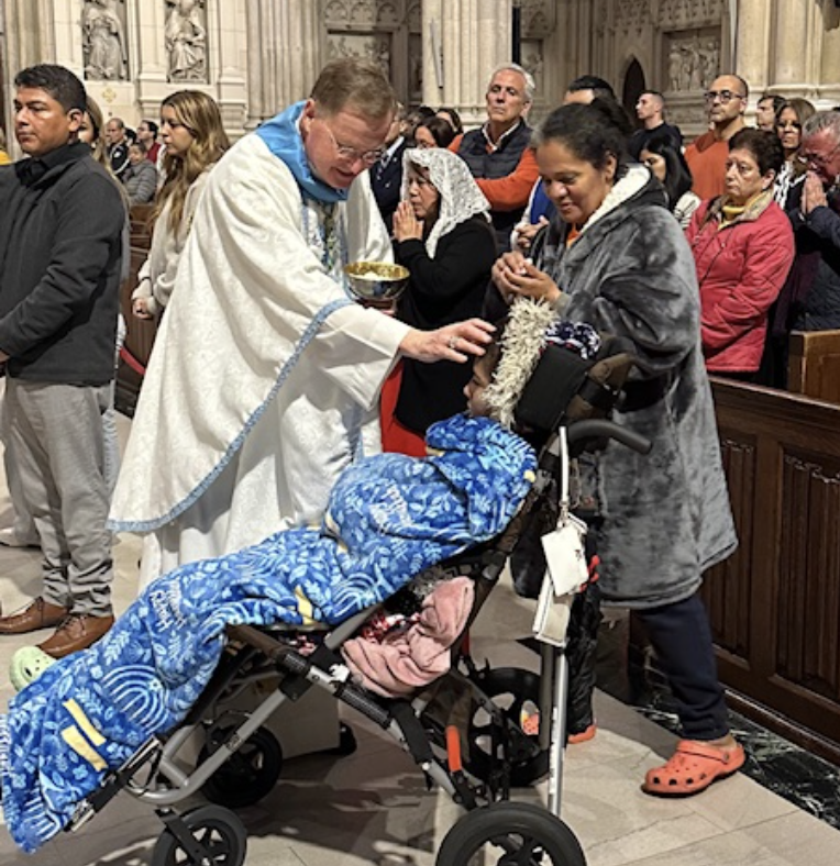 Archdiocese of New York Auxiliary Bishop Edmund J. Whalen, Vicar for Clergy, blessed a child during Communion of the annual Mass for Our Lady of Lujan, Sunday, May 5, 2024, at St. Patrick's Cathedral.