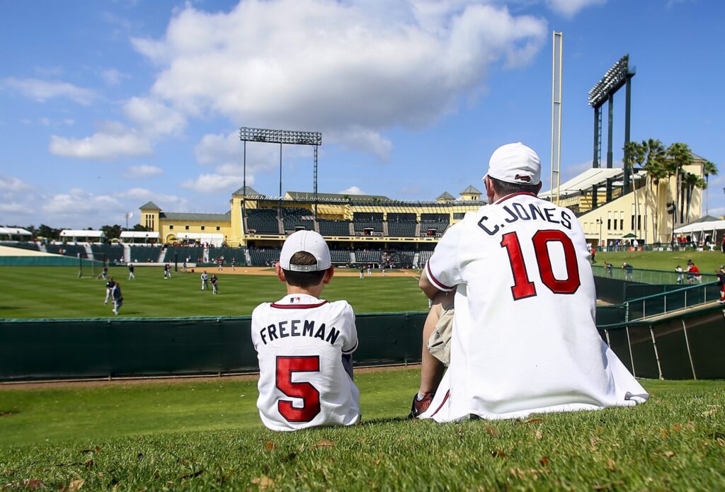 A son who sits next to his father while watching the baseball game in Lake Buena Vista, Florida, March 4, 2019.