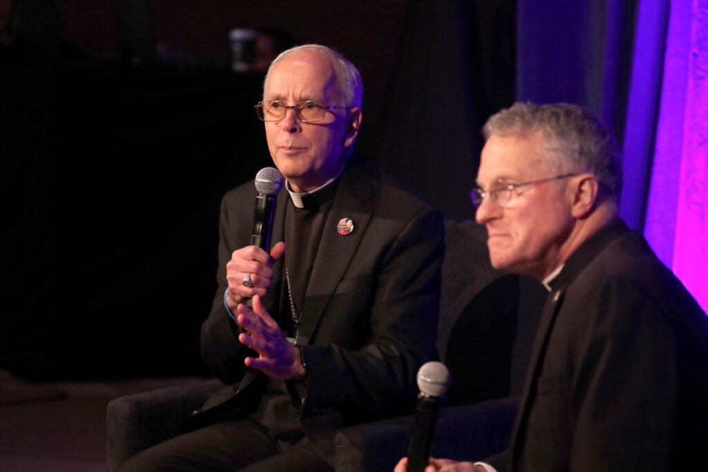 Bishop Mark J. Seitz of El Paso, Texas, gestures June 13, 2024, during a news conference at the U.S. Conference of Catholic Bishops' spring plenary assembly in Louisville, Kentucky. At right is Archbishop Timothy P. Broglio, president of the U.S. Conference of Catholic Bishops and head of the U.S. Archdiocese for the Military Service.