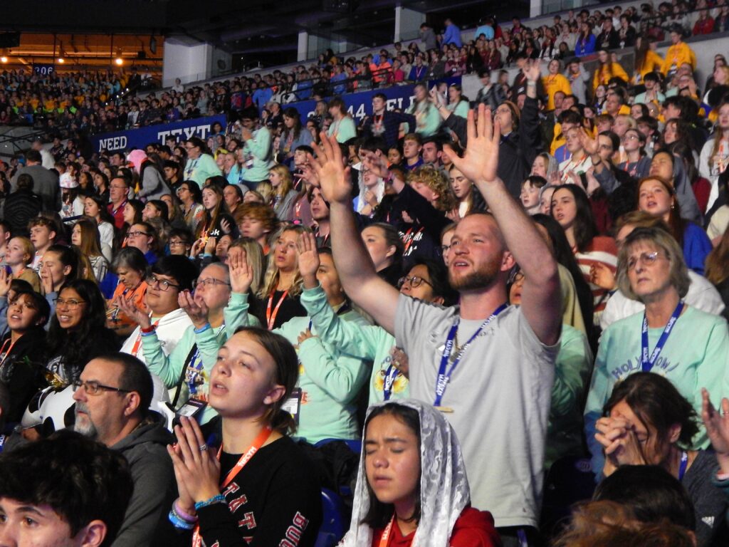 A participant prays during the closing Mass of the National Catholic Youth Conference at Lucas Oil Stadium in Indianapolis on November 18, 2023.