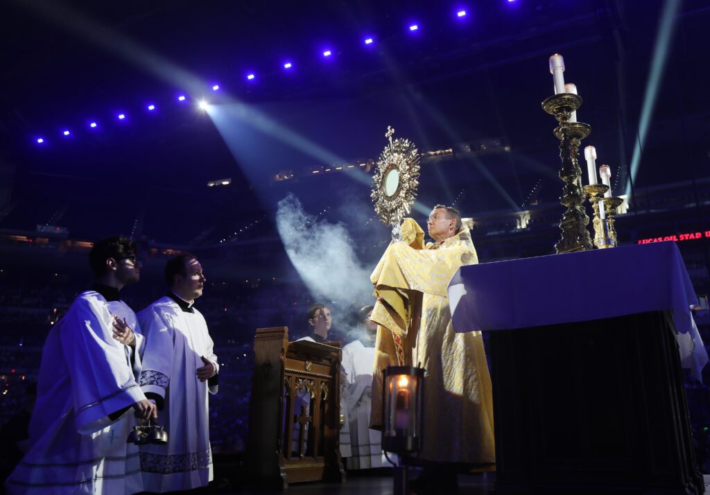 Bishop Andrew H. Cozzens of Crookston, Minnesota, chairman of the board of the National Eucharistic Congress, Inc., blesses pilgrims during adoration at the opening revival night of the 10th National Eucharistic Congress at Lucas Oil Stadium in Indianapolis July 17, 2024.