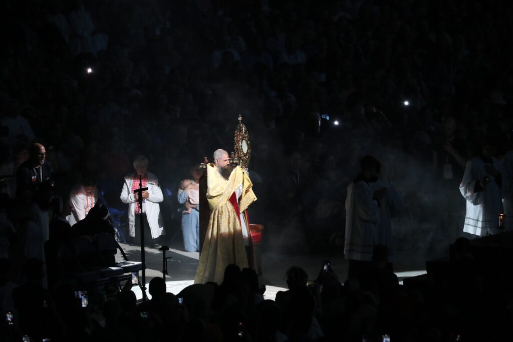 Father Boniface Hicks, a Benedictine monk of St. Vincent Archabbey in Latrobe, Pennsylvania, carries the monstrance in a procession during Eucharistic adoration on July 19, 2024, on the third revival night of the National Eucharistic Congress at Lucas Oil Stadium in Indianapolis.