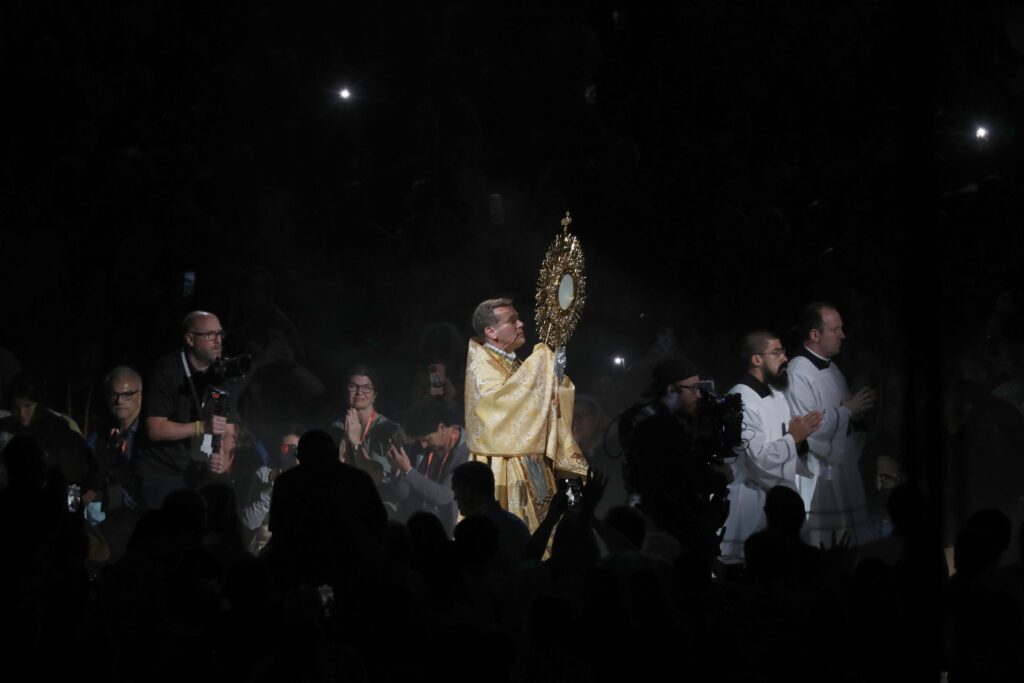 Bishop David L. Toups of Beaumont, Texas, carries the monstrance during Eucharistic adoration July 20, 2024, during the revival night of the National Eucharistic Congress at Lucas Oil Stadium in Indianapolis.