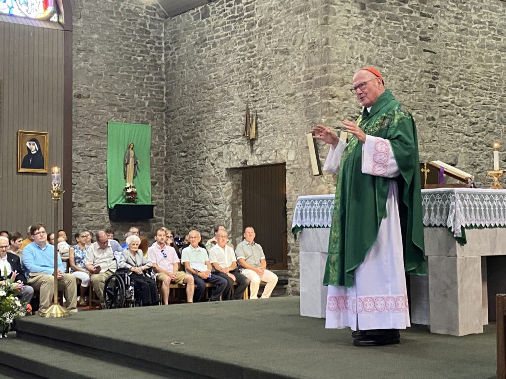 Cardinal Timothy Dolan (left) offers his homily during the 150th anniversary Mass for the Church of St. Peter in Monticello, July 14, 2024.