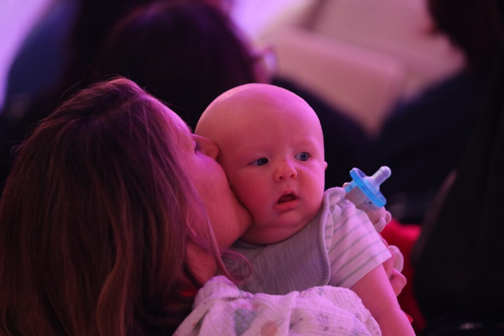 A mother kisses her baby July 19, 2024, during the revival night of the National Eucharistic Congress at Lucas Oil Stadium in Indianapolis.