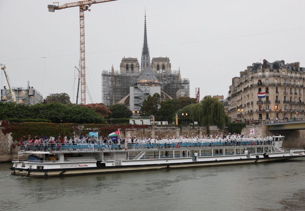 An athlete boat on the Seiner River passes in front of the Notre Dame Cathedral July 26, 2024, during the opening ceremony of the Olympic Games in Paris.