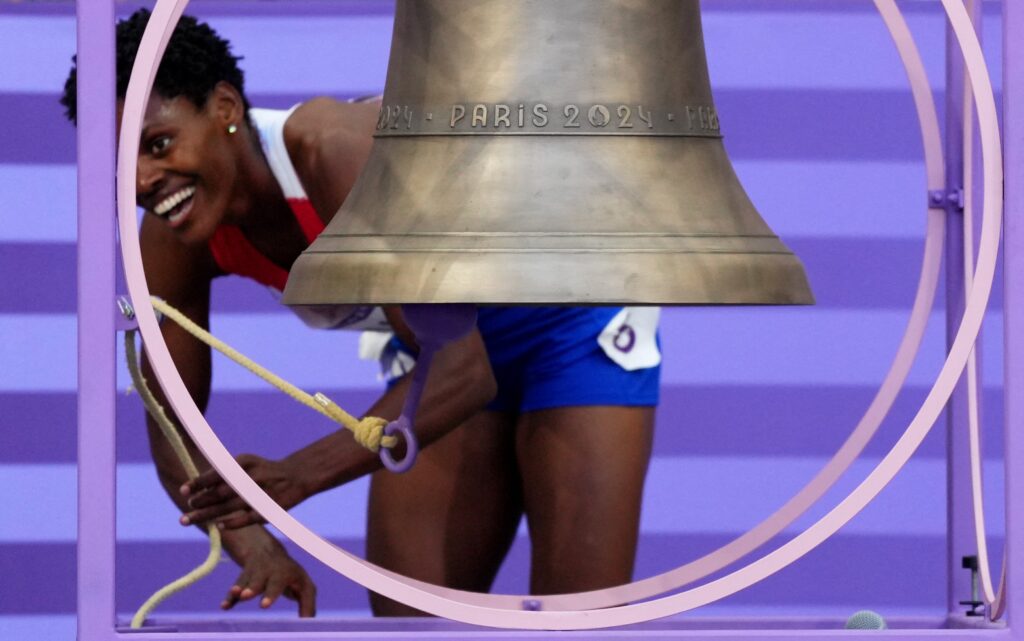 Marileidy Paulino of the Dominican Republic rings the Olympic bell on August 10, 2024, as she celebrates after winning gold and setting a new Olympic record in the women's 400-meter final during the 2024 Paris Olympics.