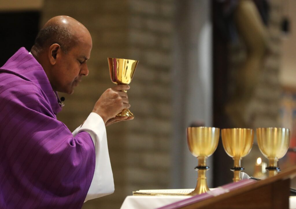 Claretian Father Gaspar Masilamani, associate pastor, raises the chalice during Communion at Sacred Heart Church in Prescott, Arizona, December 10, 2023. (OSV News photo/Bob Roller)