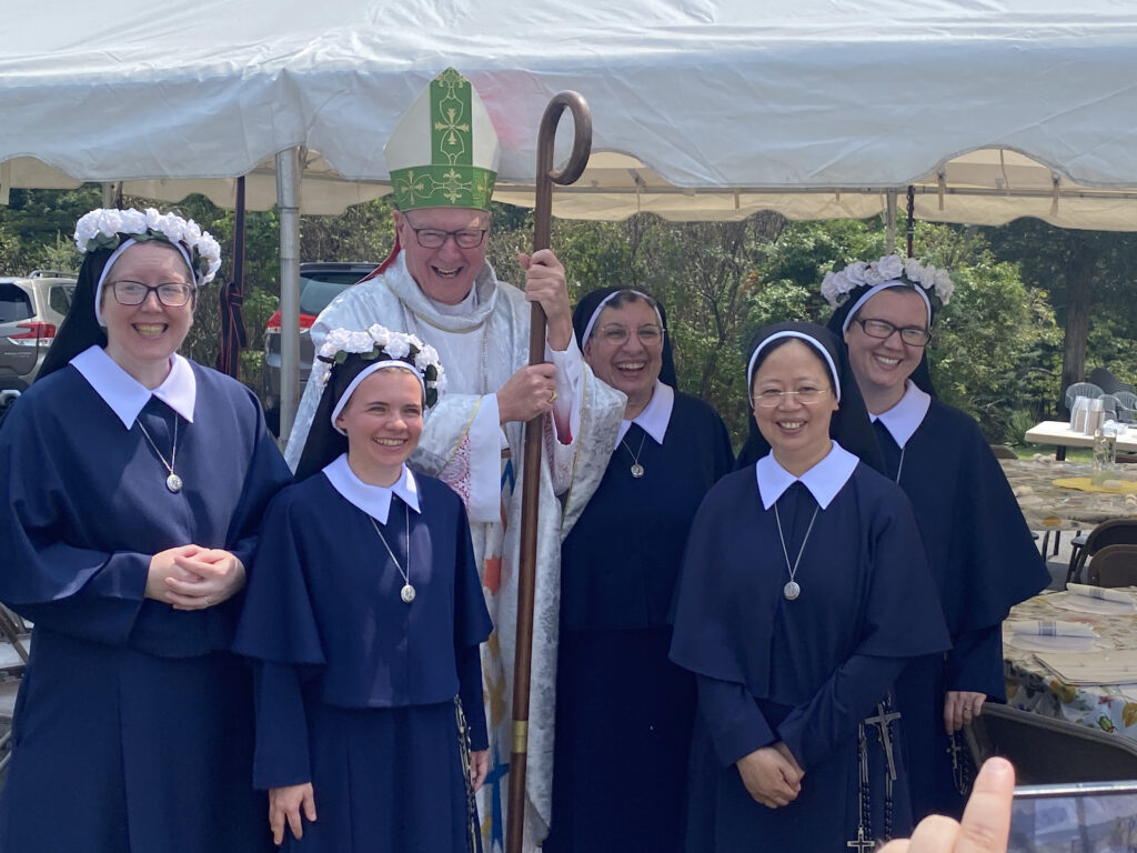 Cardinal Timothy Dolan stands with Parish Visitors of Mary Immaculate General Superior Mother Maria Catherine Iannotti (center right), and newly professed Sister Alina Marie Nieser (left), Sister Rebecca Miriam Lasota (second left), and Sister Marie Meaghan Baldwin (right), on August 15, 2024, in Monroe, New York.