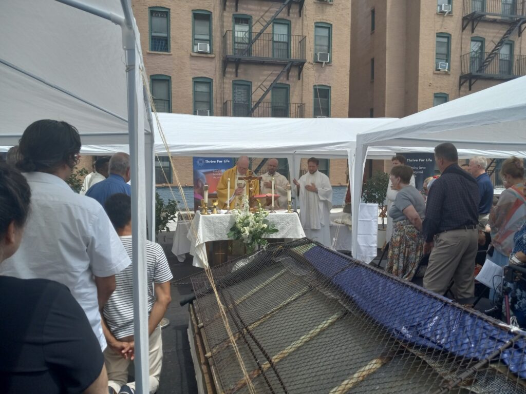 Cardinal Timothy Dolan (center, in gold vestments) consecrates the Holy Eucharist during Mass at Ignacio House in Manhattan, July 31, 2024.