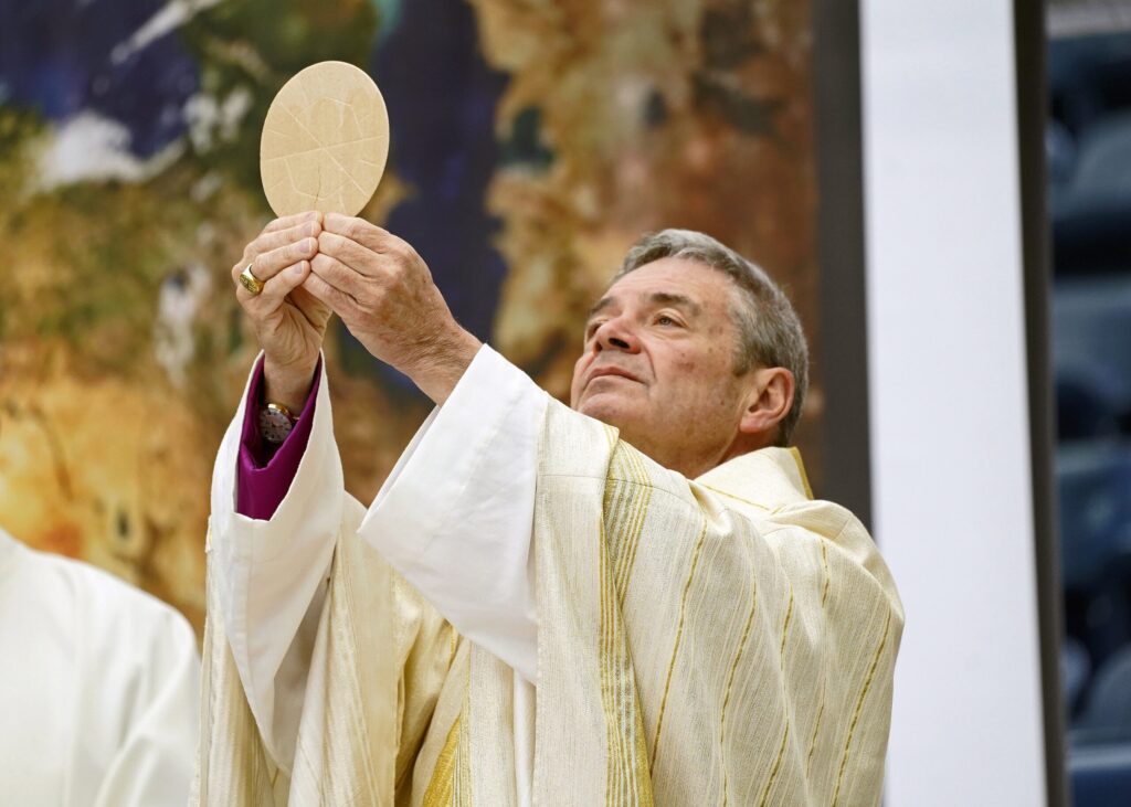 Bishop Robert J. Brennan of Brooklyn elevates the host during Mass at the Diocese of Brooklyn's Eucharistic Revival at Louis Armstrong Stadium at the USTA Billie Jean King National Tennis Center in Flushing, April 20, 2024.