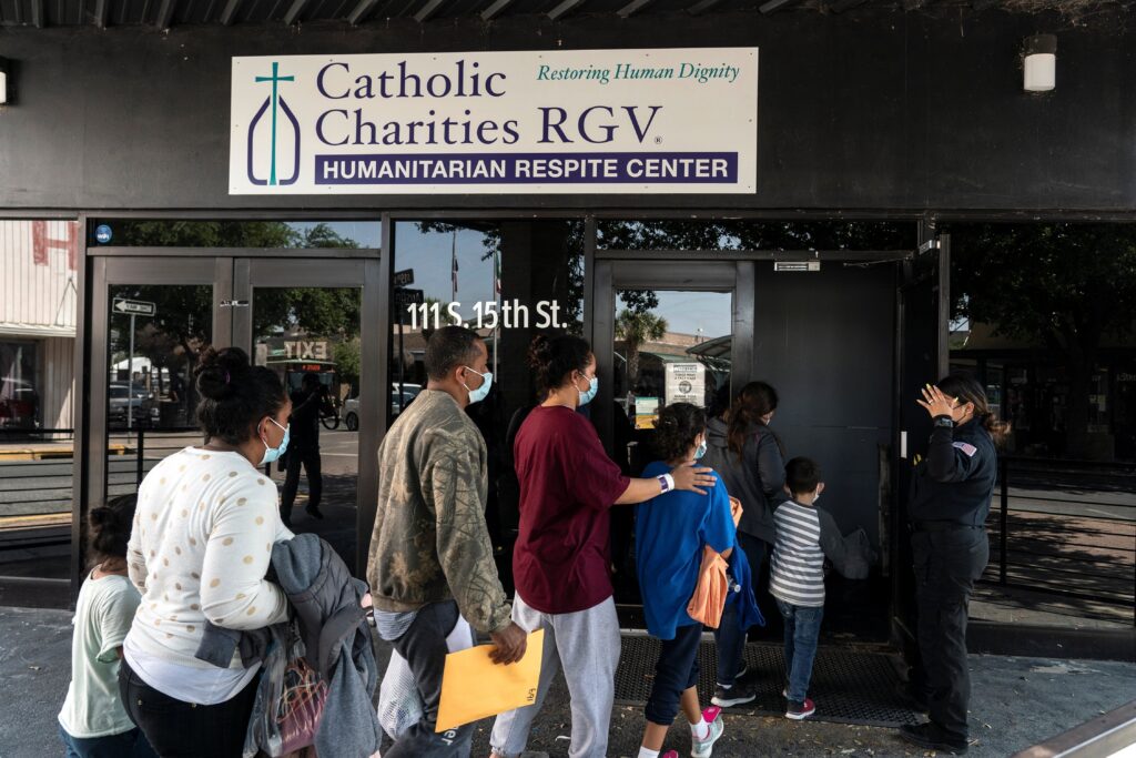 Migrants seeking asylum in the U.S. walk into a temporary humanitarian respite center run by Catholic Charities of the Rio Grande Valley in McAllen, Texas, April 8, 2021.