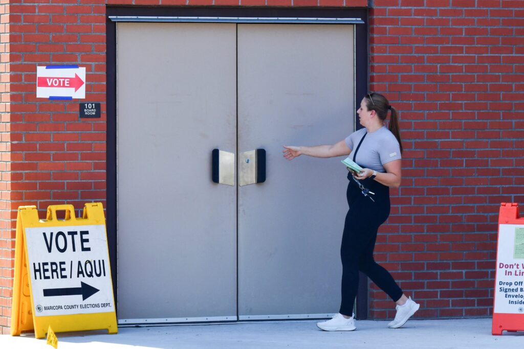 A voter walks into a polling location with an early ballot at Osborn Elementary School in Phoenix on July 30, 2024.