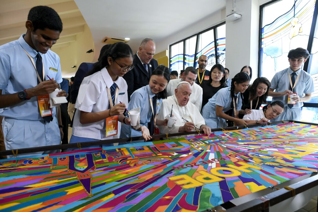 Pope Francis makes his contribution to a painting commemorating his trip to Singapore after a meeting with young people at the Catholic Junior College in Singapore September 13, 2024.