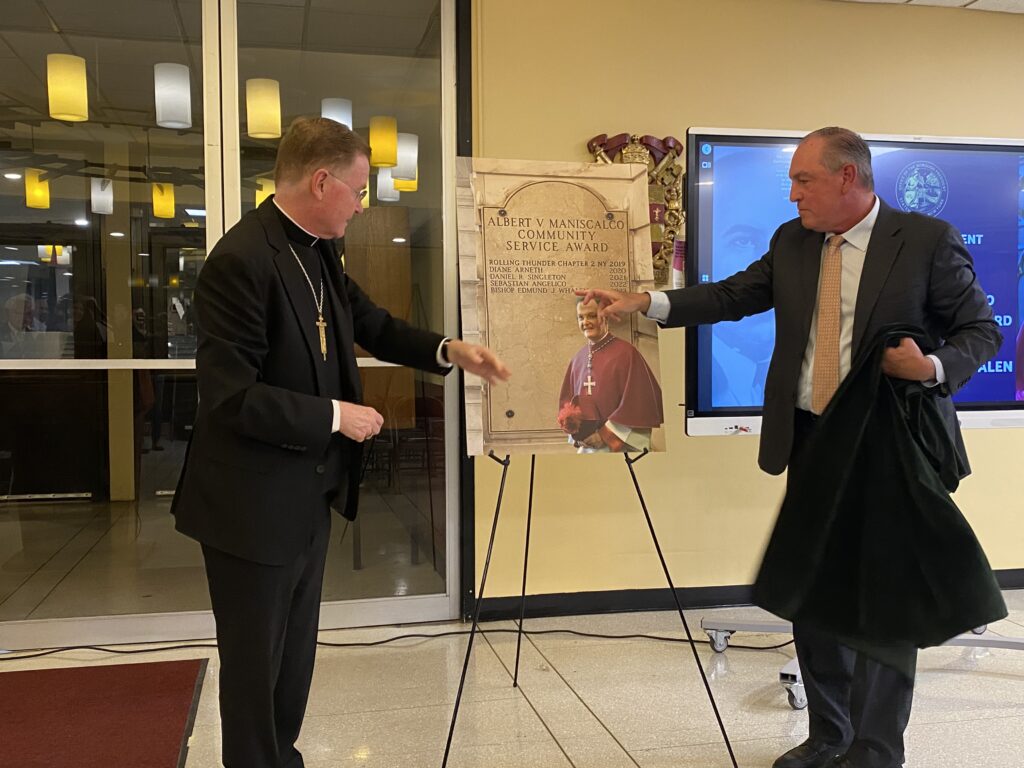 Archdiocese of New York Auxiliary Bishop Edmund J. Whalen (left), vicar for clergy, and Staten Island Borough President Vito Fossella unveil a replica of the Albert V. Maniscalco Award that Bishop Whalen received on September 18, 2024, at Monsignor Farrell High School in the Oakwood Heights section of Staten Island.