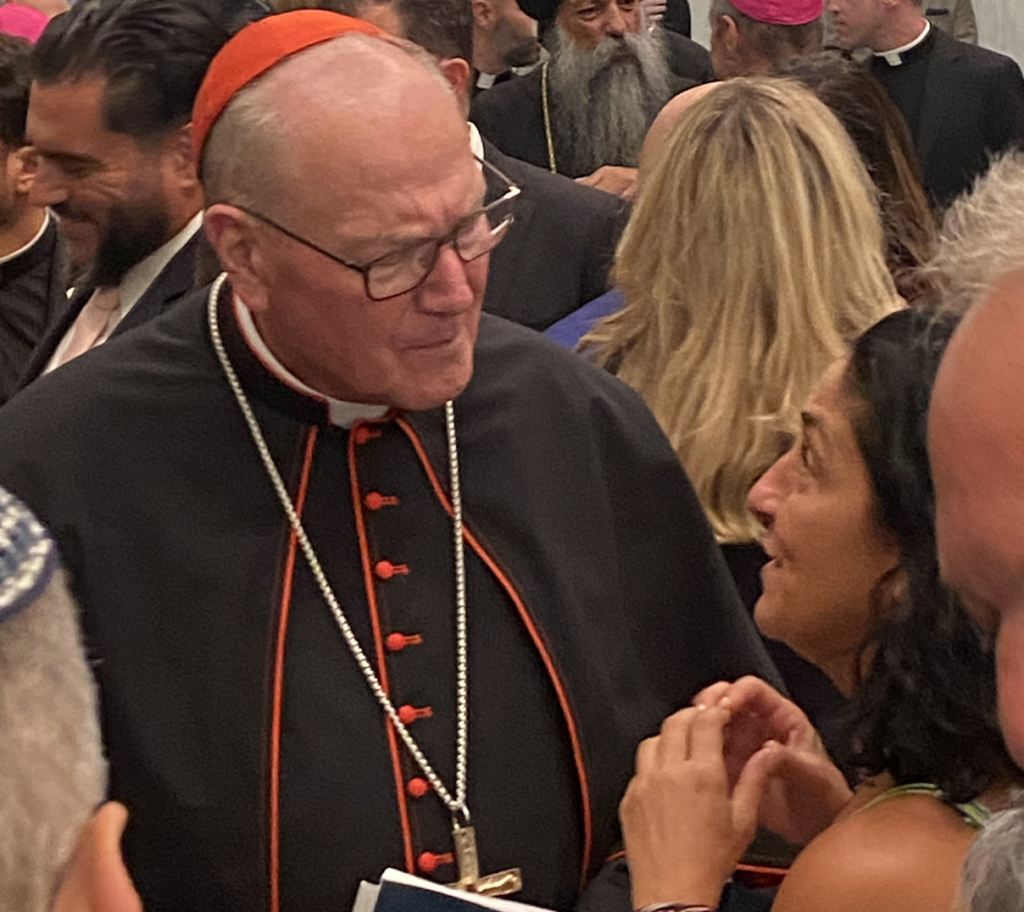 Cardinal Timothy Dolan listens to Anthoula Katsimatides (right), sister of John Katsimatides (right), who was killed in the 9/11 attacks.