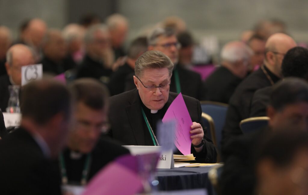 Auxiliary Bishop Andrzej J. Zglejszewski of Rockville Centre looks over paperwork during a November 15, 2023, session of the fall general assembly of the U.S. Conference of Catholic Bishops in Baltimore.