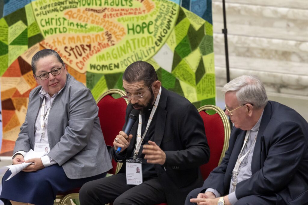 Bishop Daniel E. Flores of Brownsville, Texas, responds to questions from U.S. university students about the Synod of Bishops in the Paul VI Audience Hall at the Vatican October 18, 2024. He is seated between Company of Mary Sister Leticia Salazar, a U.S. synod delegate, left, and Cardinal Jean-Claude Hollerich, the synod relator general.