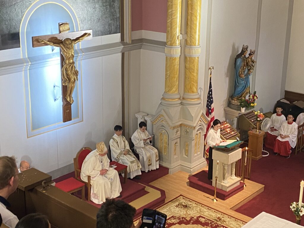 Cardinal Timothy Dolan (left) listens during Mass at the Church of the Transfiguration in Manhattan's Chinatown, August 13, 2023. A stained glass window was damaged in a vandalism incident on September 30, 2024.