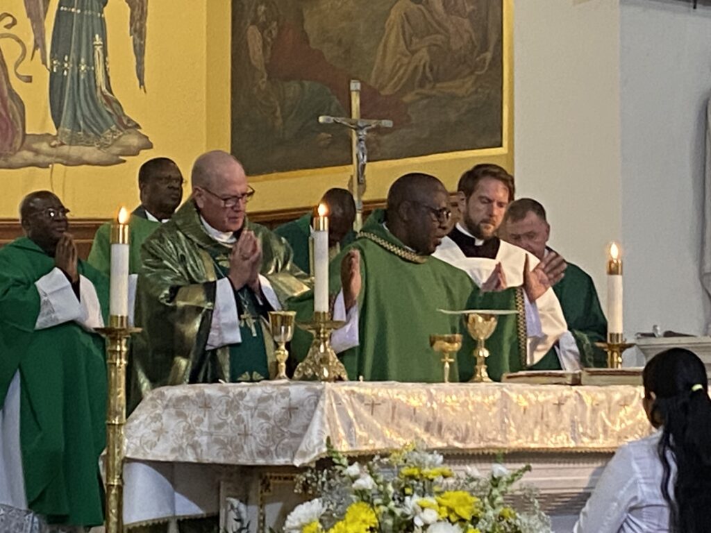 Father Gerald Mugabi, AJ, (center) concelebrates his first Mass as St. Cecilia-Holy Agony Church’s pastor, with Cardinal Timothy Dolan (left) as principal celebrant and homilist, on Saturday, October 26, 2024.