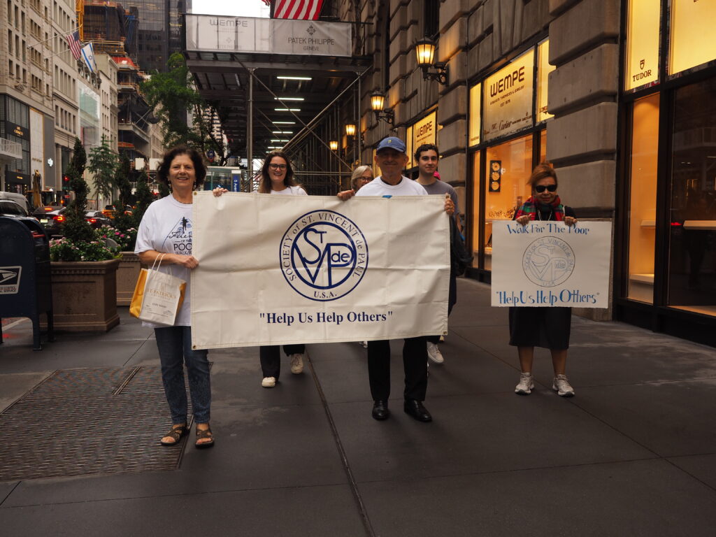 Participants in the Friends of the Poor Walk organized by the St. Vincent De Paul Society of the Archdiocese of New York hold a banner on Saturday, September 28, 2024.