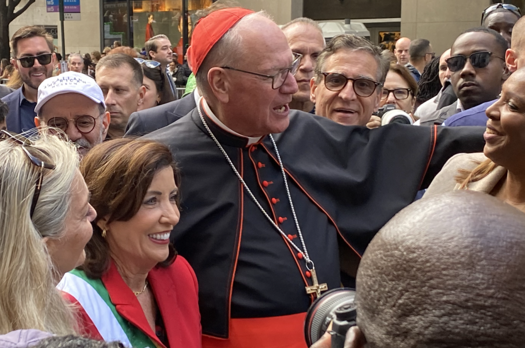 Cardinal Timothy Dolan greets Governor of New York Kathy Hochul (in red) at the 2024 Columbus Day Parade in front of St. Patrick's Cathedral, October 14, 2024.