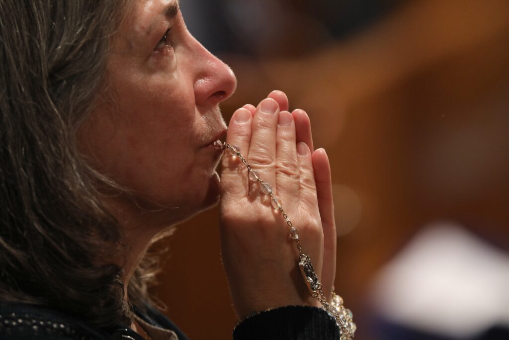 A woman becomes emotional as she prays with a rosary during Eucharistic adoration following the opening Mass of the National Prayer Vigil for Life Jan. 19, 2023, at the Basilica of the National Shrine of the Immaculate Conception in Washington.