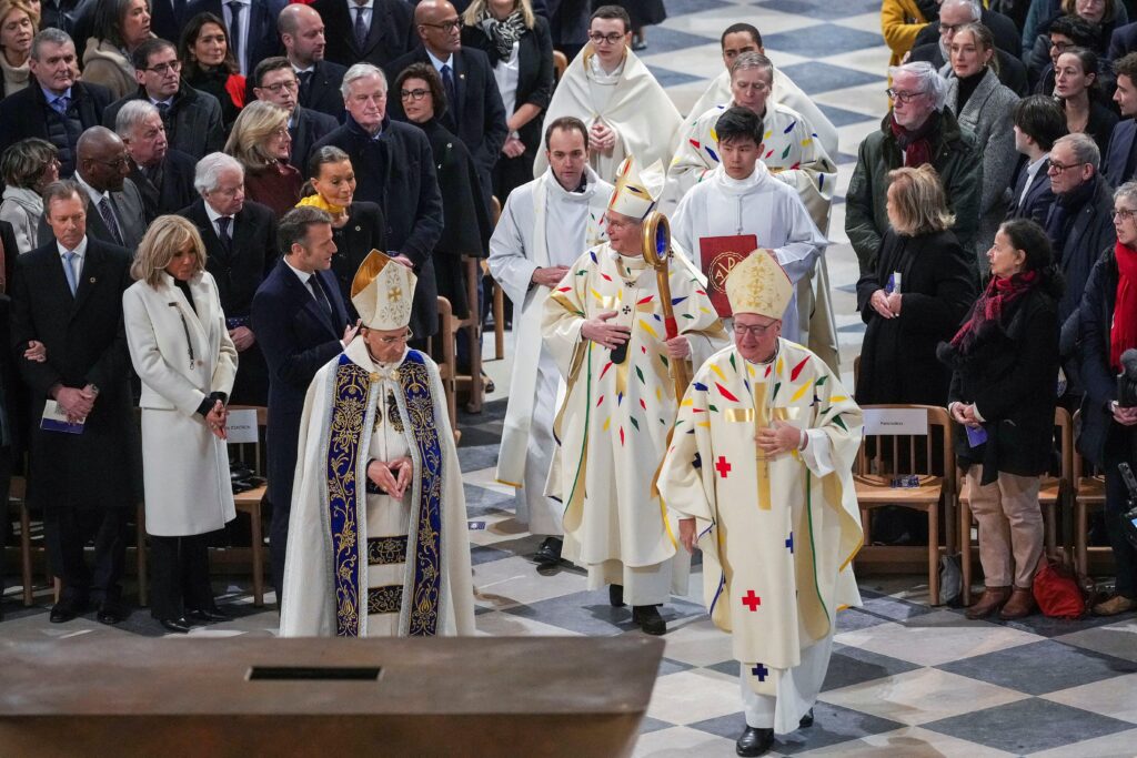 Archbishop Laurent Ulrich of Paris processes down the aisle for the inaugural Mass at Notre Dame Cathedral, with Cardinal Timothy M. Dolan of New York and Lebanese Cardinal Bechara Rai, patriarch of the Maronite Catholic Church, leading the way as French President Emmanuel Macron and his wife Brigitte Macron look on, five-and-a-half years after a fire ravaged the Gothic masterpiece, as part of ceremonies to mark the cathedral's reopening after its restoration, in Paris, December 8, 2024.