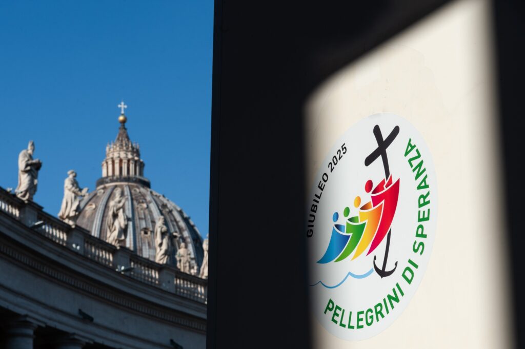 The is a combination photo of St. Peter’s Basilica and the logo chosen by the Vatican for the Holy Year 2025.