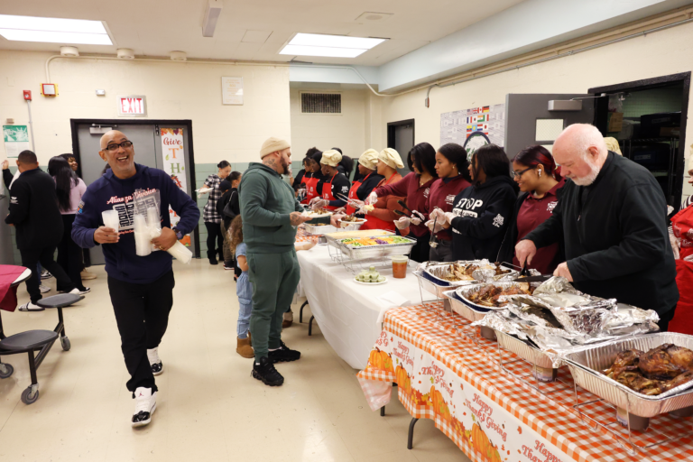 Monsignor Kevin Sullivan (right) serves food to those in the Harlem community.