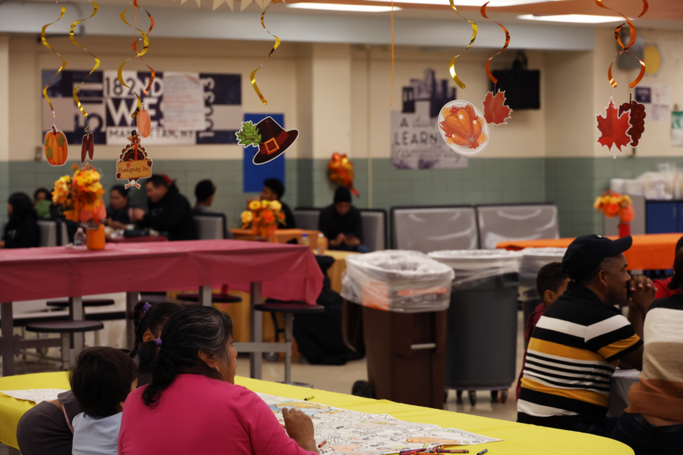 The decorated event space creates an inviting atmosphere as a family participates in a coloring activity for kids in attendance.