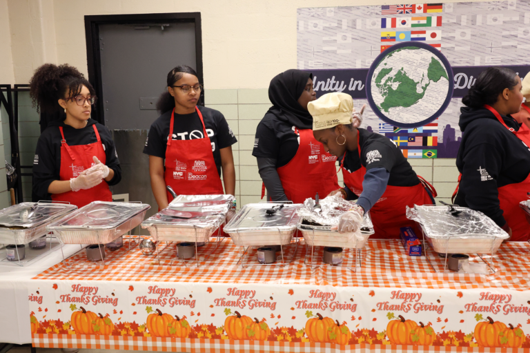 Students from Alianza’s Youth Appointment Program prepare the tins for the line of people to come up and eat.