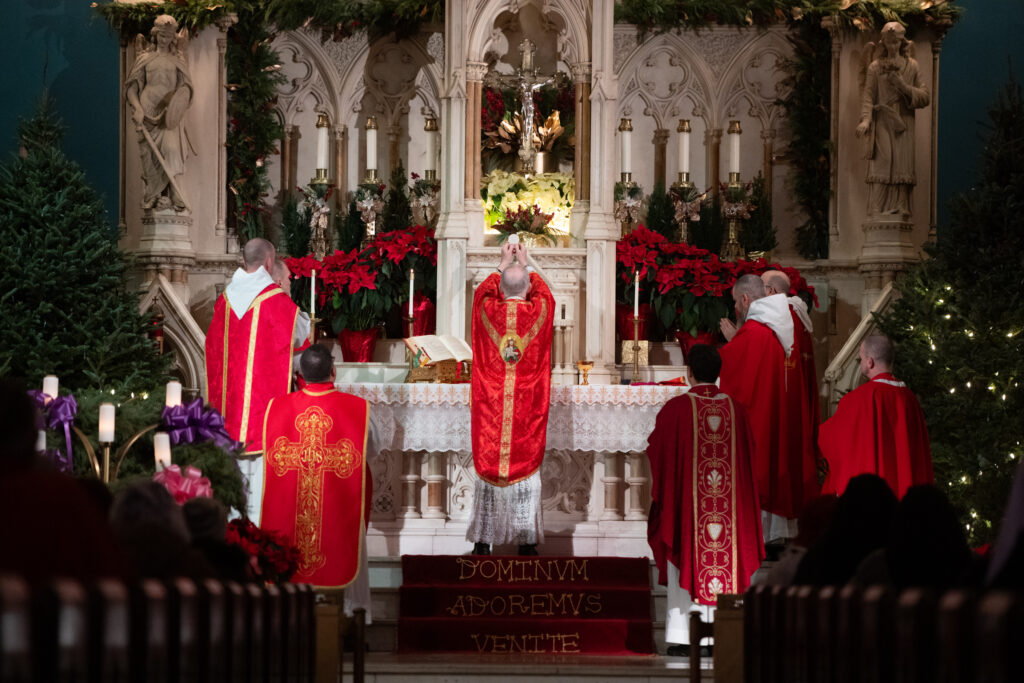 Archdiocese of New York Auxiliary Bishop Peter Byrne (center) raises the Eucharist during the celebration of Mass on the Feast of the Holy Innocents at Holy Innocents Church in Manhattan, Saturday, December 28, 2024.