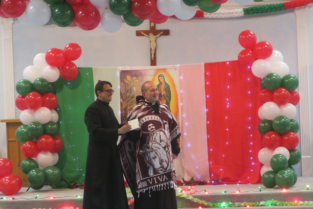 Father Arthur Rojas (left) presents a check to St. Mary-St. Andrew's Parish's Father Kenneth Riello, pastor of the Ellenville parish, for its food pantry on December 12, 2024.