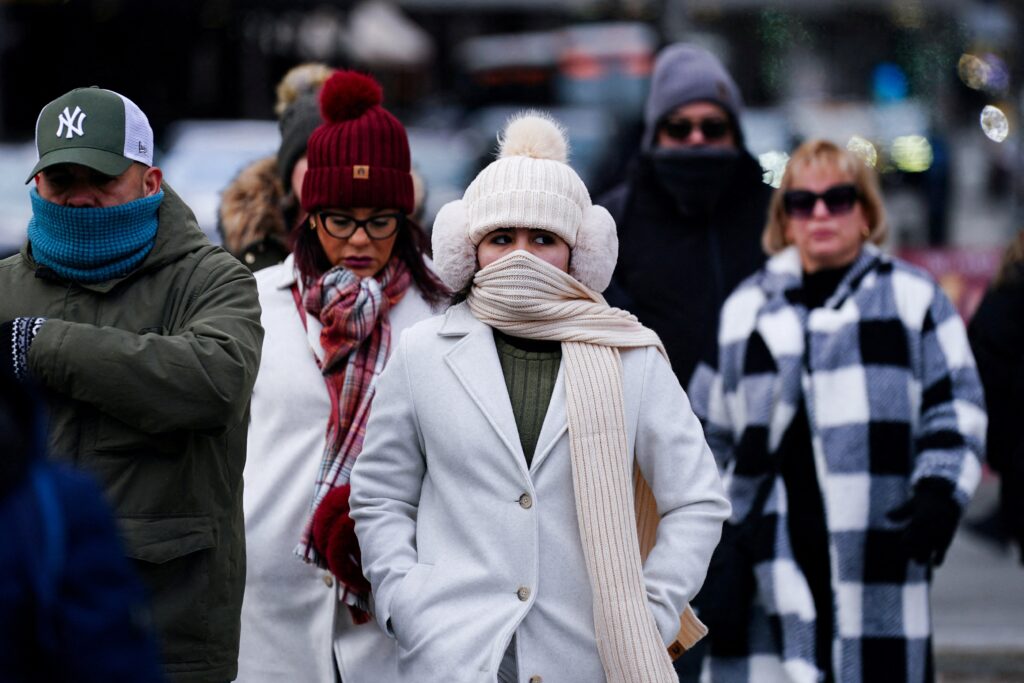 People cross the street in Manhattan during cold weather in New York City January 5, 2025.