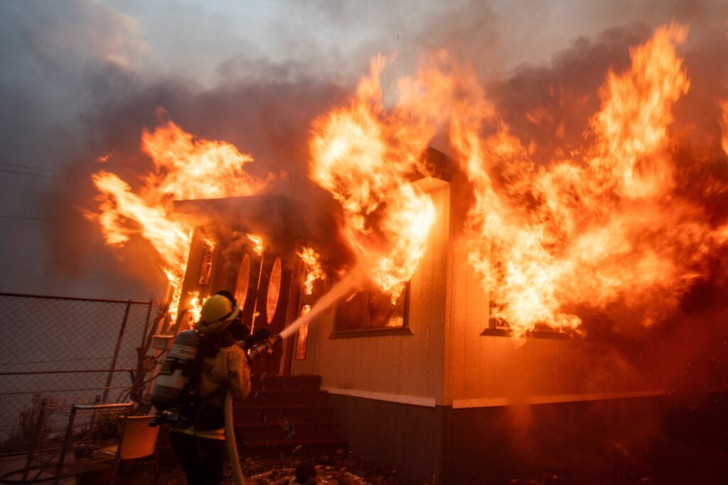 A firefighter battles the Palisades Fire as it burns during a weather-driven windstorm on the west side of Los Angeles January 7, 2025. Wildfires tore across the Los Angeles area with devastating force January 8 after setting off a desperate escape for residents from burning homes through flames, ferocious winds and towering clouds of smoke. (OSV News photo/Ringo Chiu, Reuters)