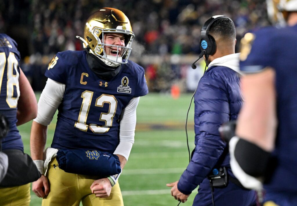 Notre Dame Fighting Irish quarterback Riley Leonard celebrates with head coach Marcus Freeman after scoring a touchdown during the second half against the Indiana Hoosiers at Notre Dame Stadium December 20, 2024, in Notre Dame, Indiana.