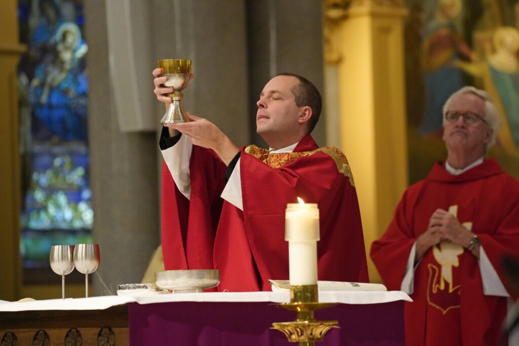 Father Jamie Dennis, who is blind and serves as a pastor in the Diocese of Owensboro, Kentucky, elevates the chalice as he concelebrates a Mass marking the feast of St. Lucy, patroness of the blind, at St. Francis Xavier Church in Manhattan on December 13, 2024.