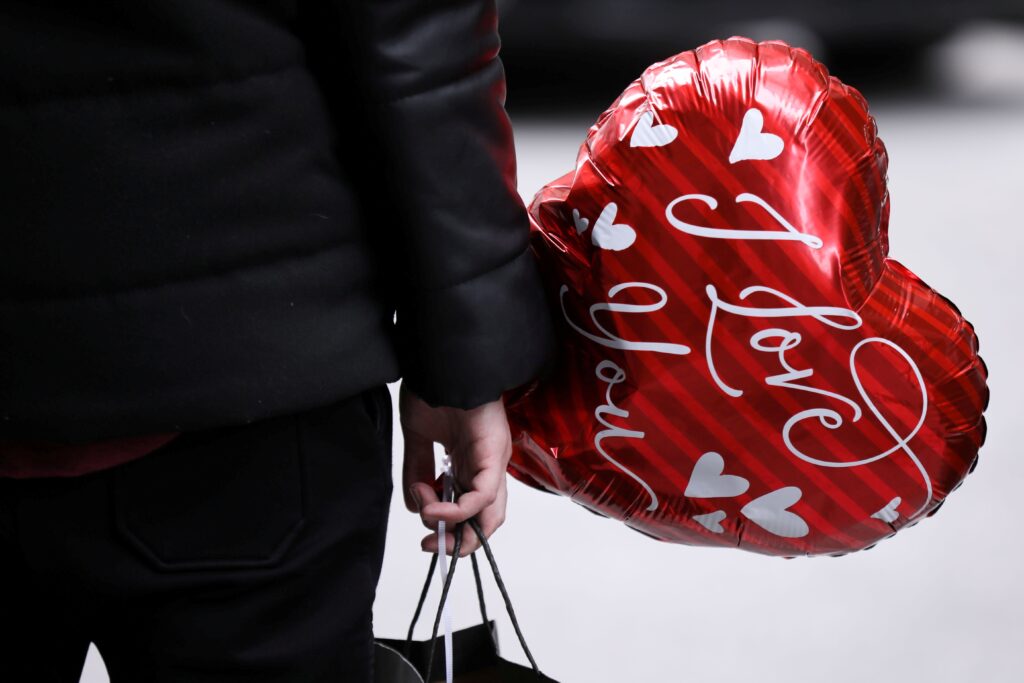 A man in New York city holds a balloon on Valentine's Day February 14, 2021.