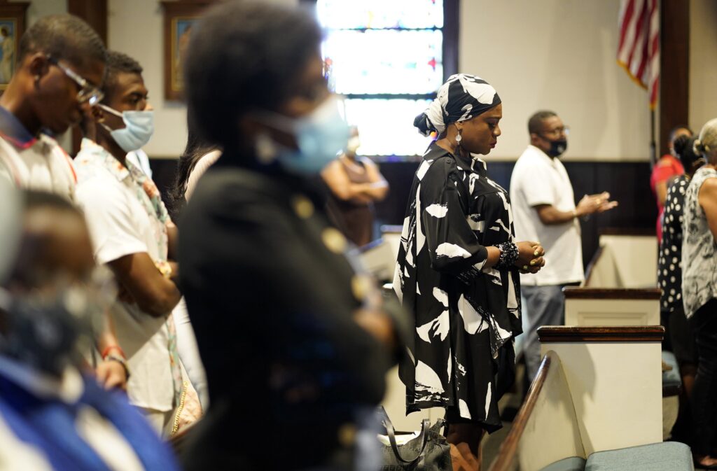 Worshippers pray during a weekly Sunday Mass at St. Martha Church in Uniondale on August 15, 2021.