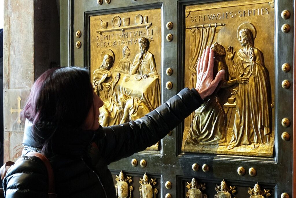 A visitor passes through the Holy Door of St. Peter’s Basilica at the Vatican on February 8, 2025, during the Jubilee of the Armed Services, Police and Security Personnel.